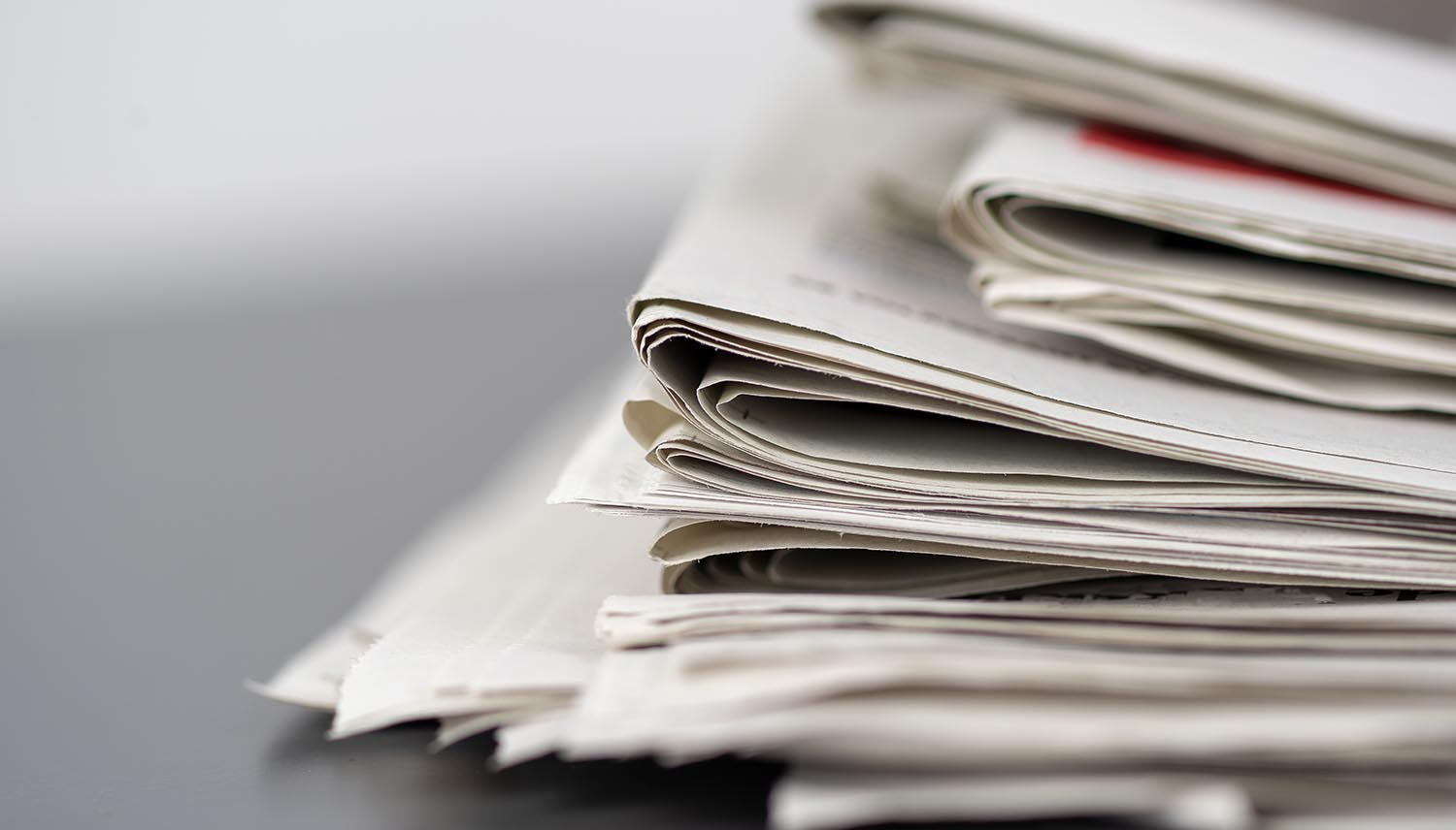 Closeup shot of several newspapers stacked on top of each other